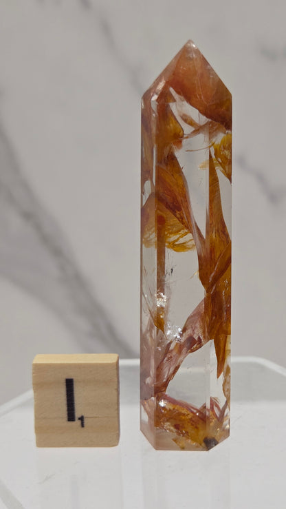 Golden Healer tower on a clear stand against a white background