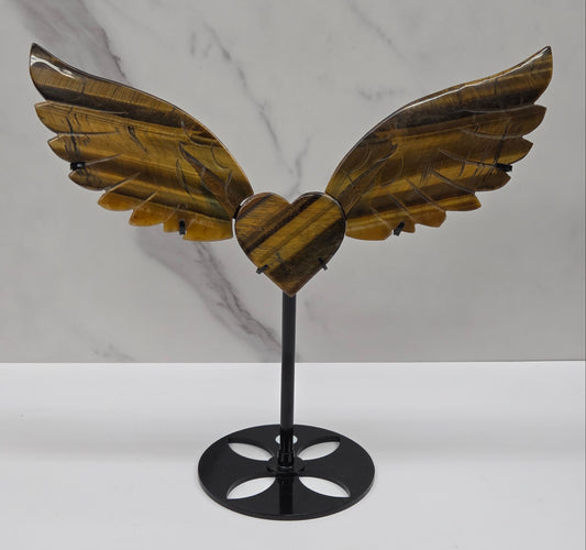Decorative Tigers eye wings and a heart on a black stand on a neutral background