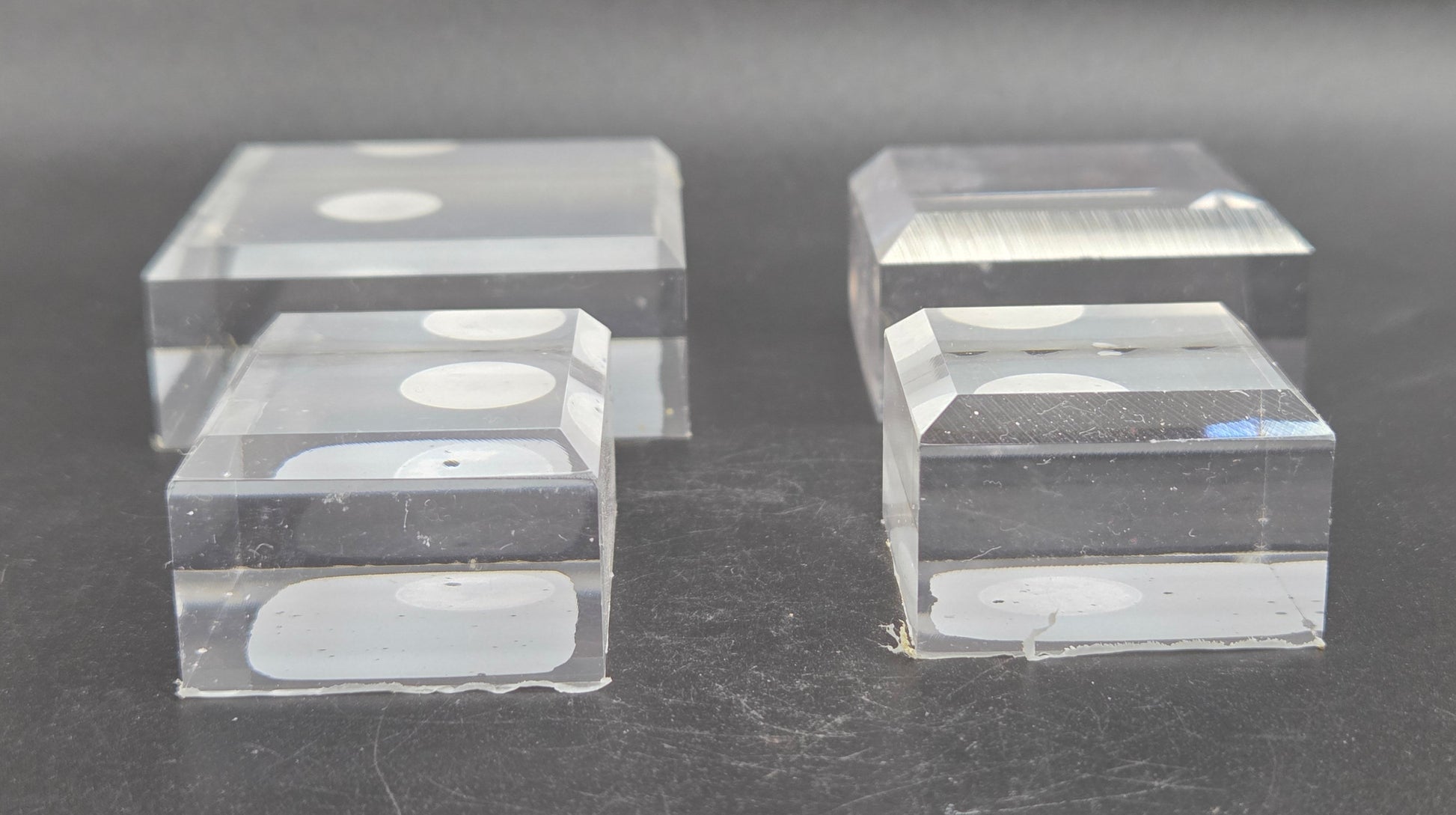 Four clear acrylic blocks on a dark surface