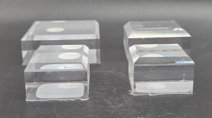 Four clear acrylic blocks on a dark surface