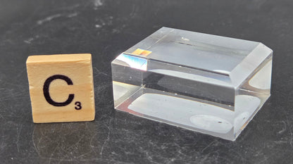 Clear rectangular block next to a wooden block with 'C' and number '3' on a dark surface