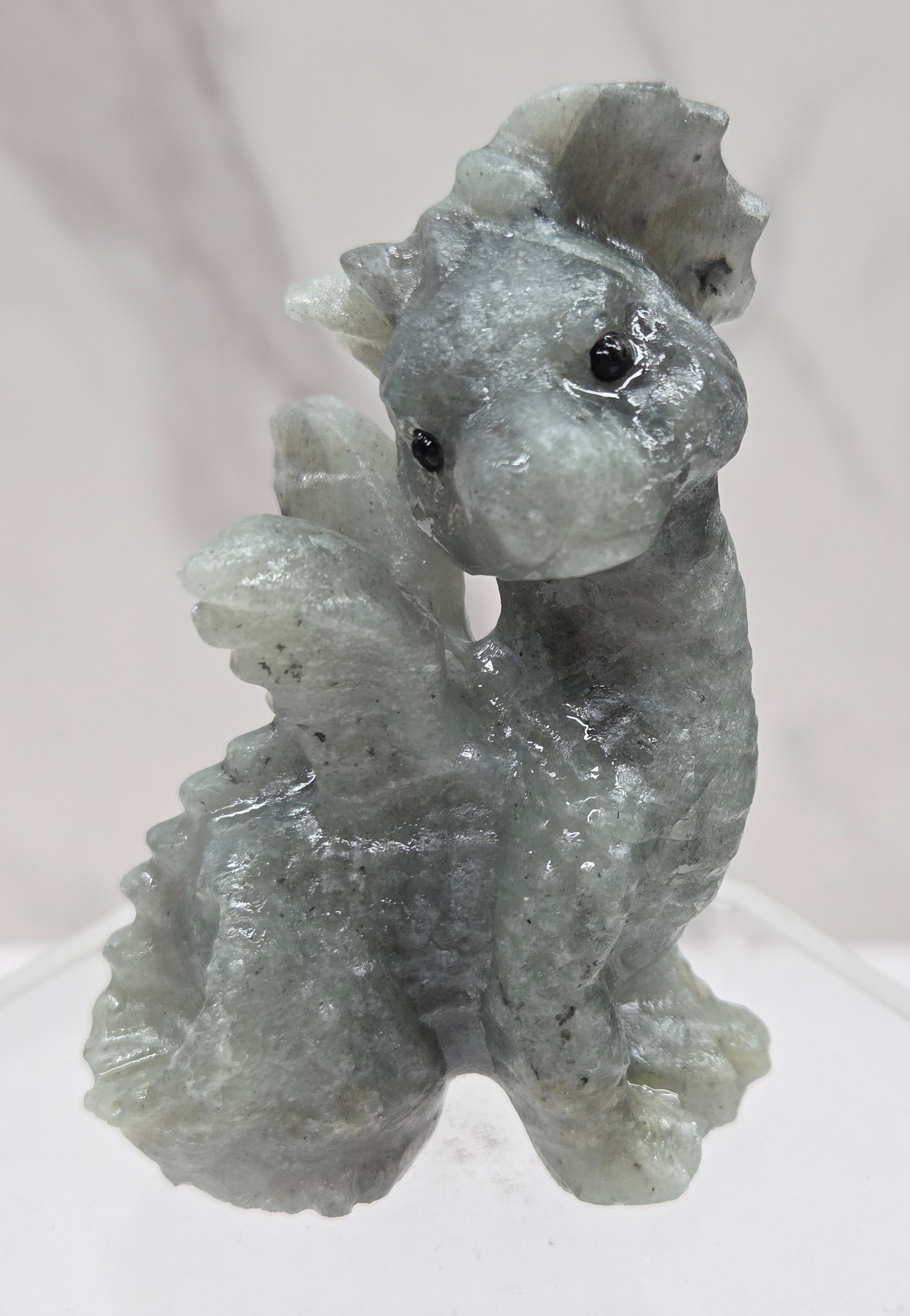 Labradorite dragon carving on an acrylic stand against a neutral background