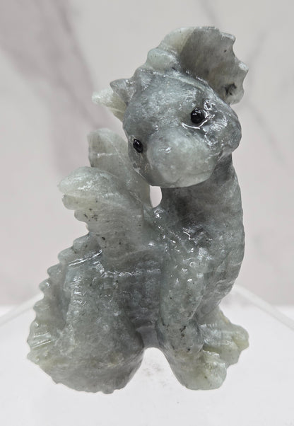 Labradorite dragon carving on an acrylic stand against a neutral background