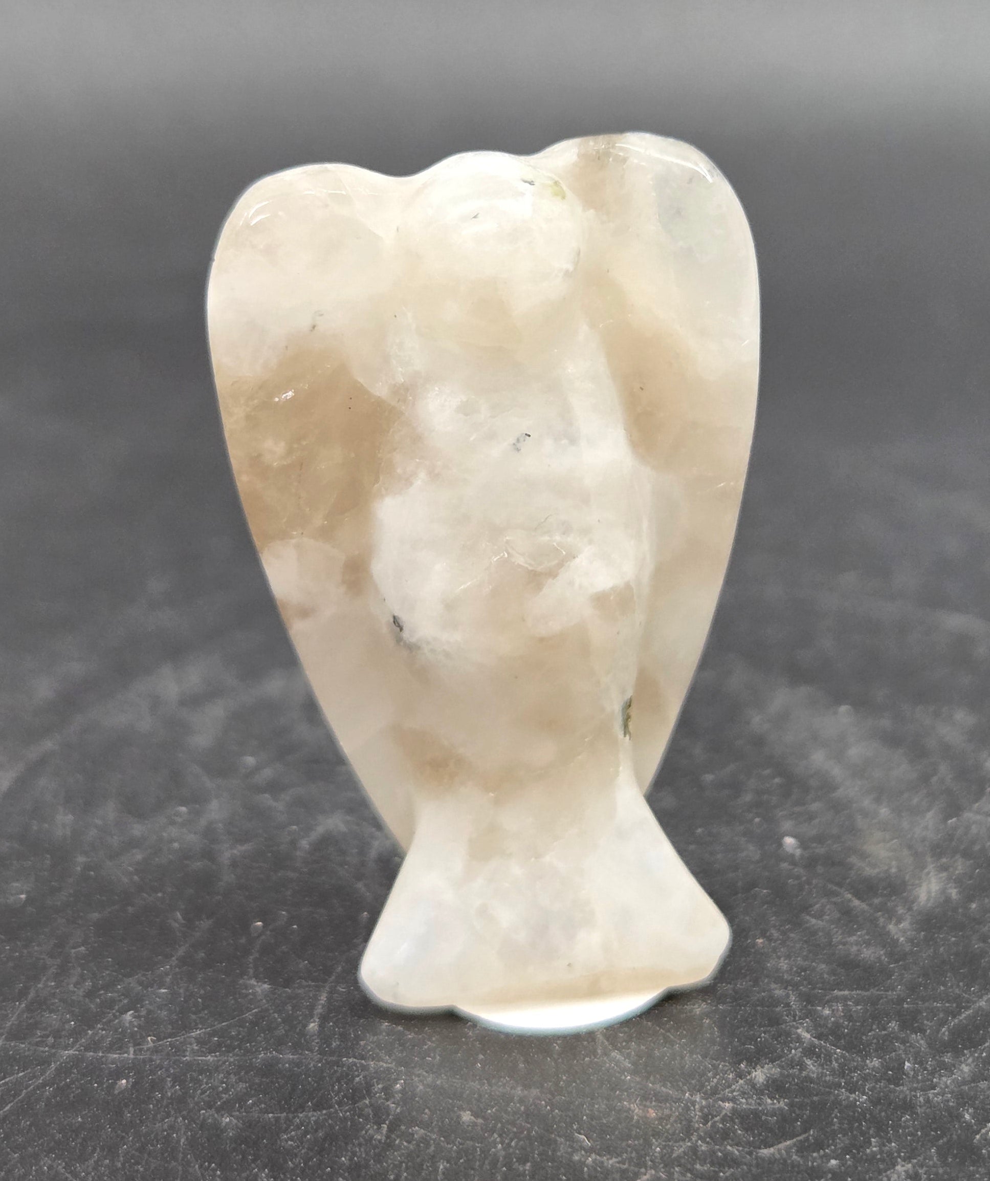 Small white angel figurine on a dark gray background