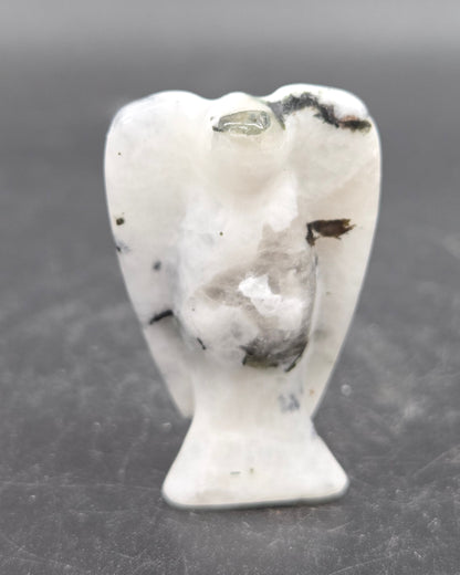 Small white angel figurine on a dark gray background
