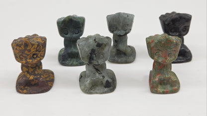 Set of six small stone Groot sculptures on a white background