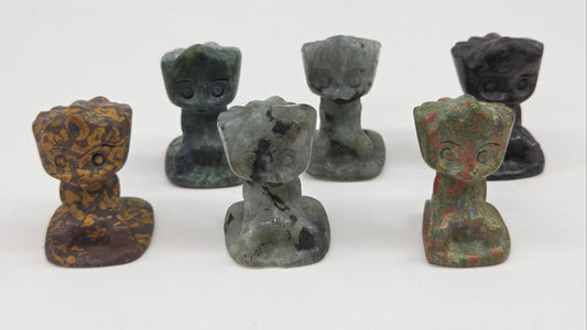 Set of six small stone Groot sculptures on a white background