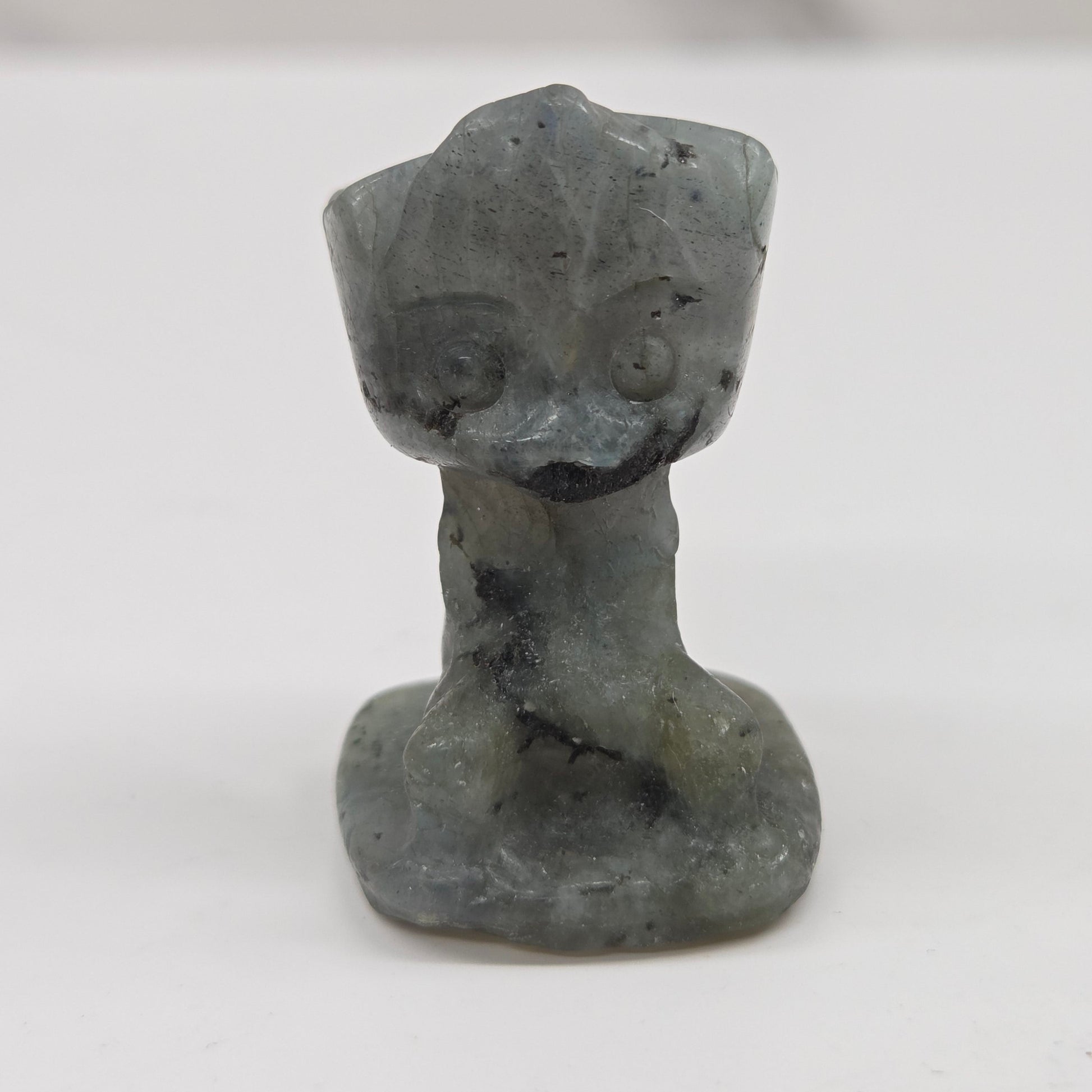 Labradorite sculpture of Groot on a white background