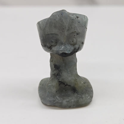 Labradorite sculpture of Groot on a white background