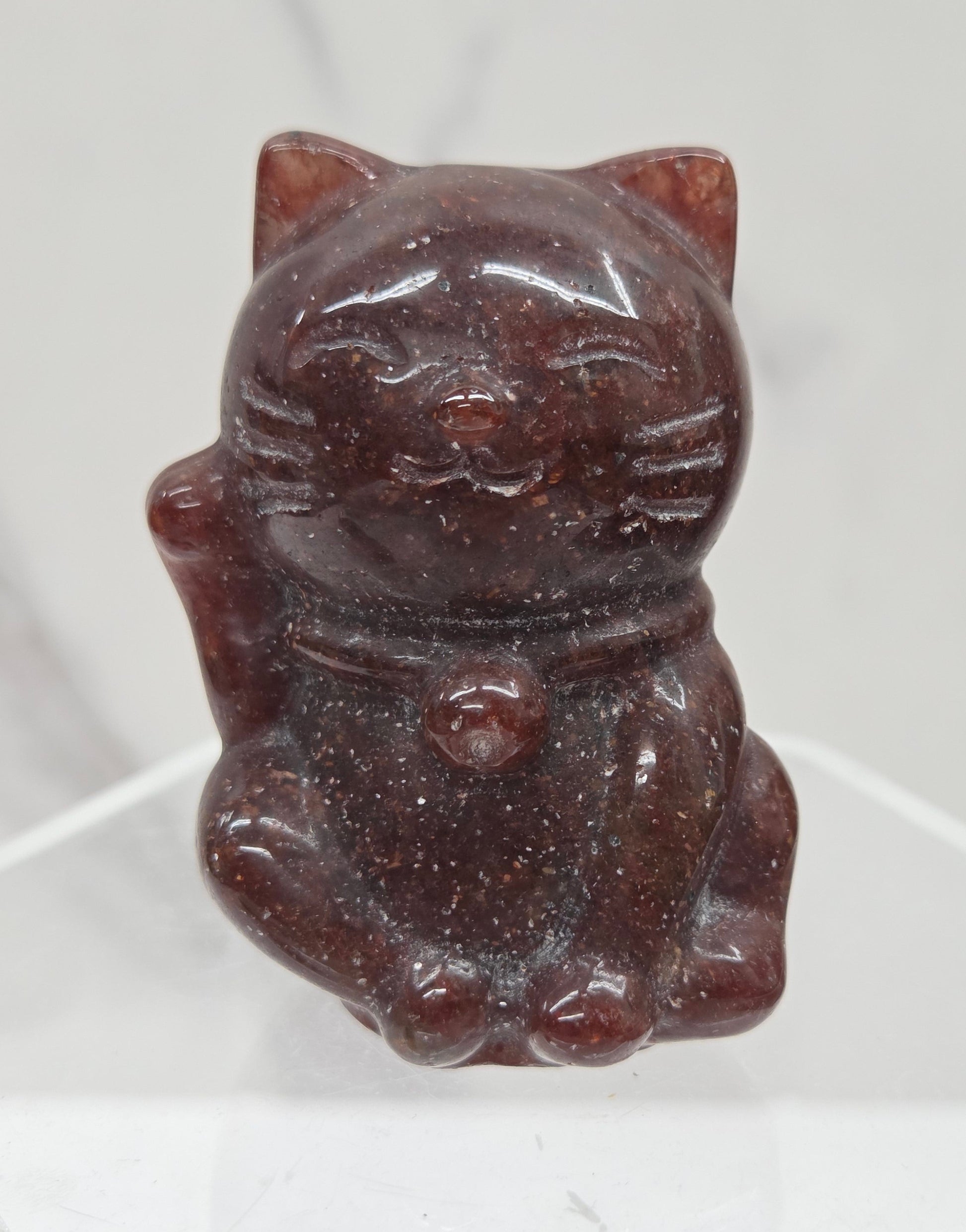 Red stone carved in the shape of a cat on a white background