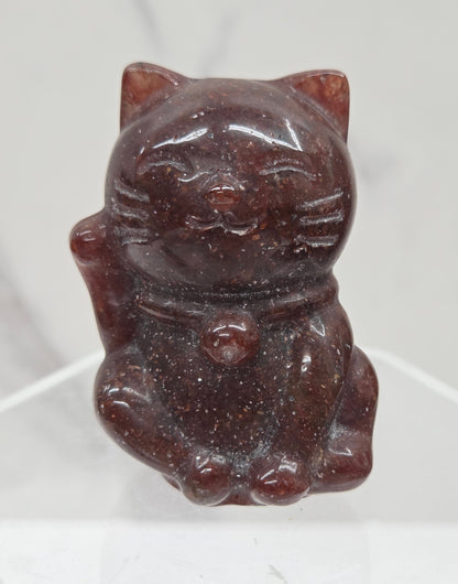 Red stone carved in the shape of a cat on a white background