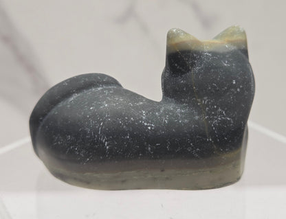 Jasper cat carving lying down an acrylic stand against a neutral background