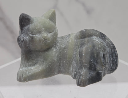 Jasper cat carving lying down an acrylic stand against a neutral background