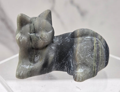 Jasper cat carving lying down an acrylic stand against a neutral background