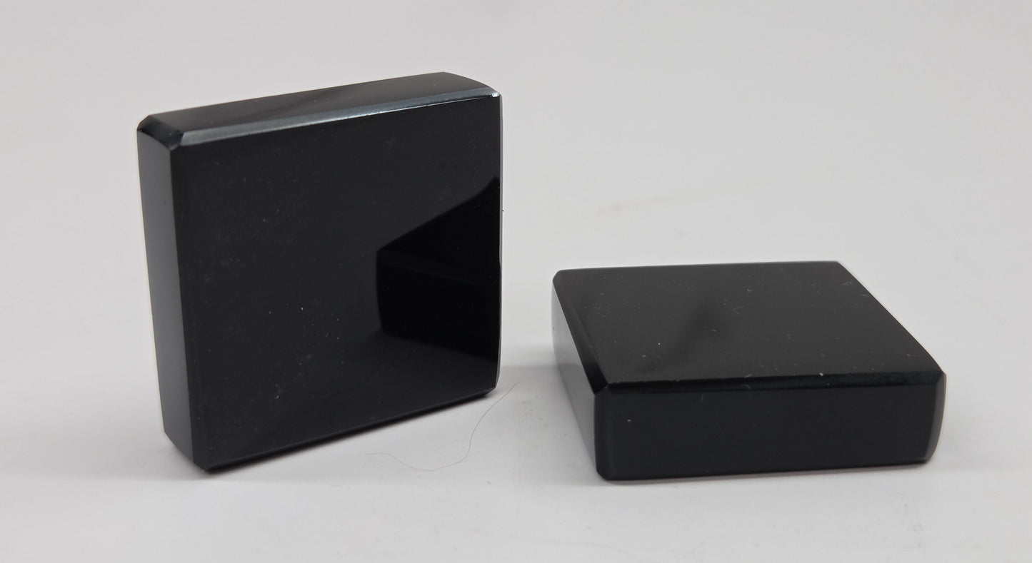 Two black Obsidian square blocks on a white background