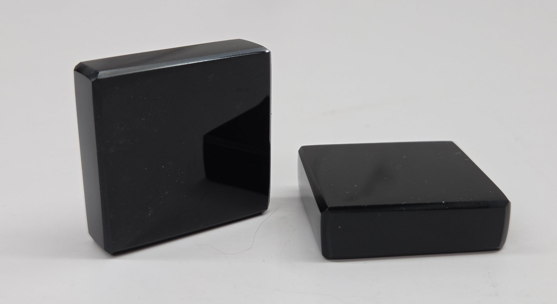 Two black Obsidian square blocks on a white background