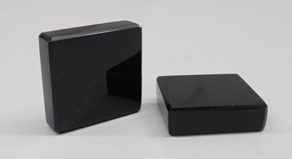 Two black Obsidian square blocks on a white background