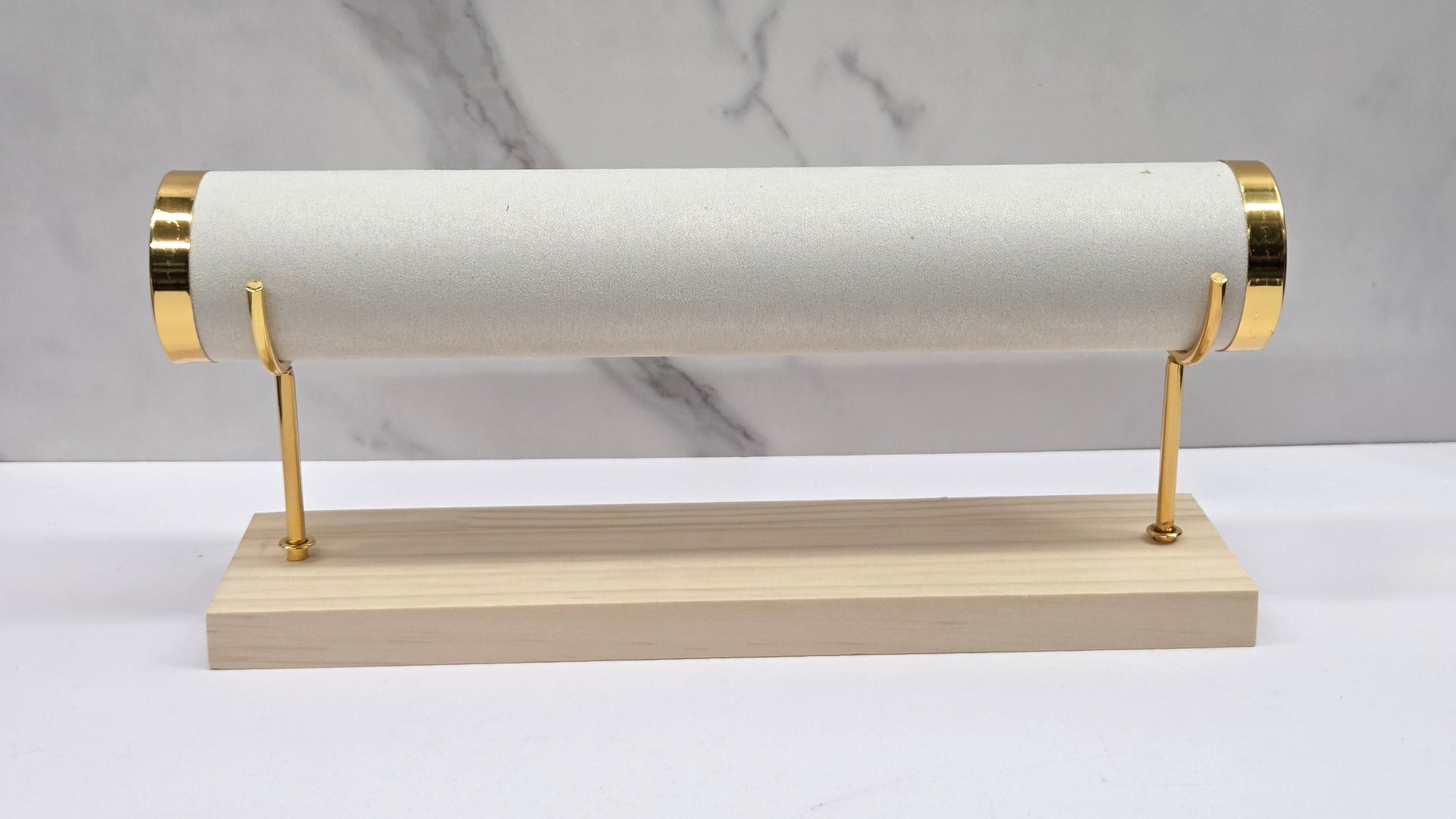 Single-tiered bracelet holder with gold accents on a marble background