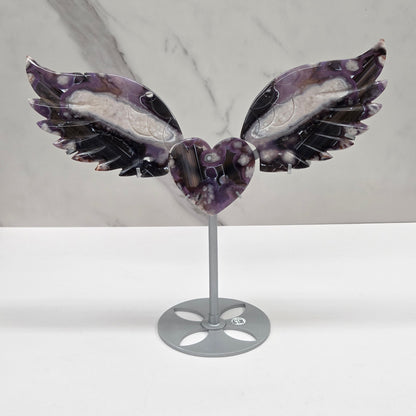 Black Flower Agate carved into wings and hearts on a silver stand against a white background.