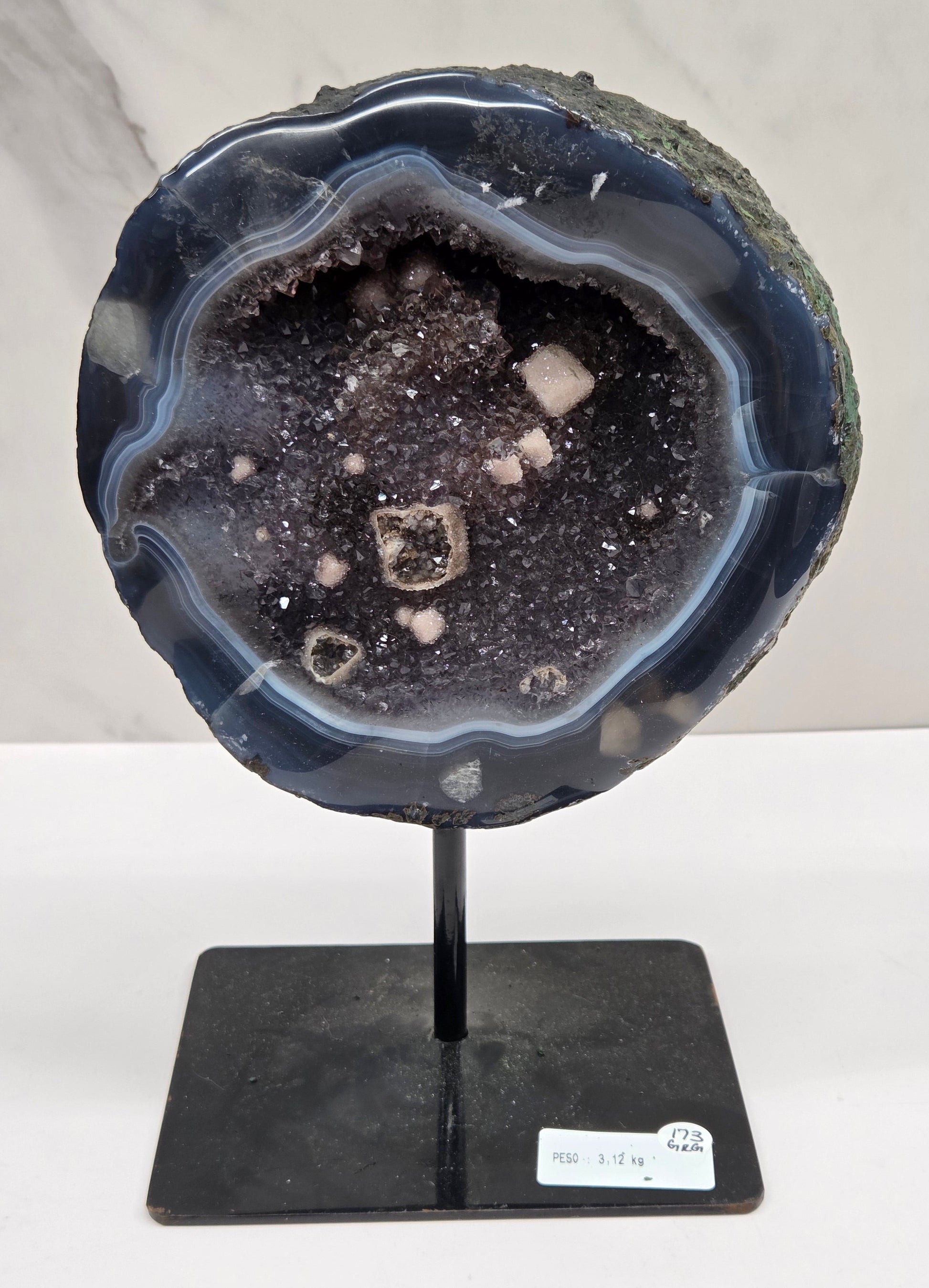 Amethyst and Agate round geode with white calcite inclusions on a black stand against a white background