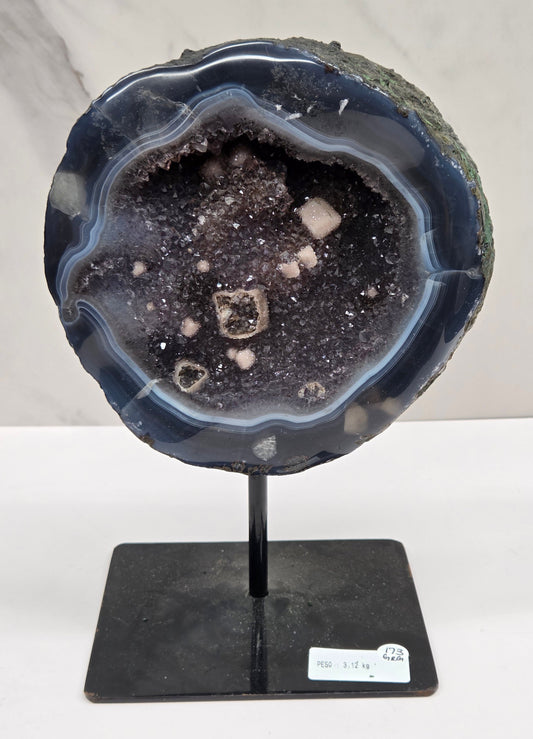 Amethyst and Agate round geode with white calcite inclusions on a black stand against a white background