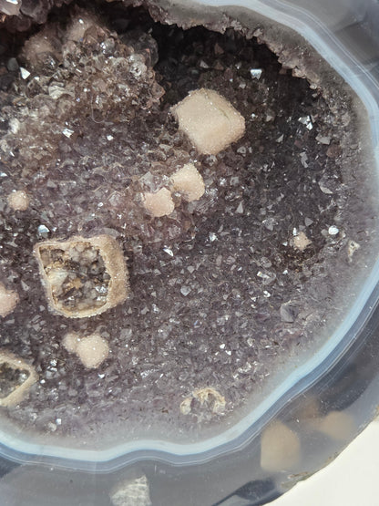 Close-up of an Amethyst and Agate round geode with white calcite inclusions