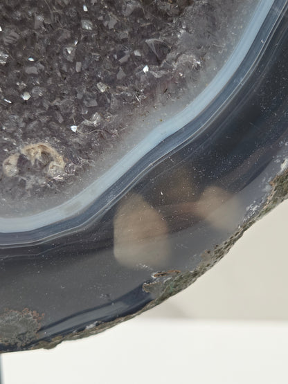 Close-up of an Amethyst and Agate round geode with white calcite inclusions