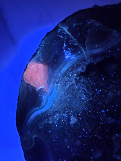 Amethyst and Agate round geode with white calcite inclusions under UV light