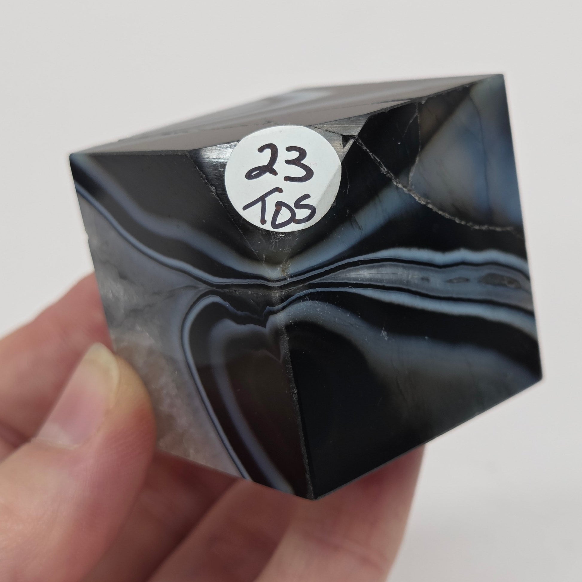 Black Agate cube shape with black and white banding and quartz on a white background