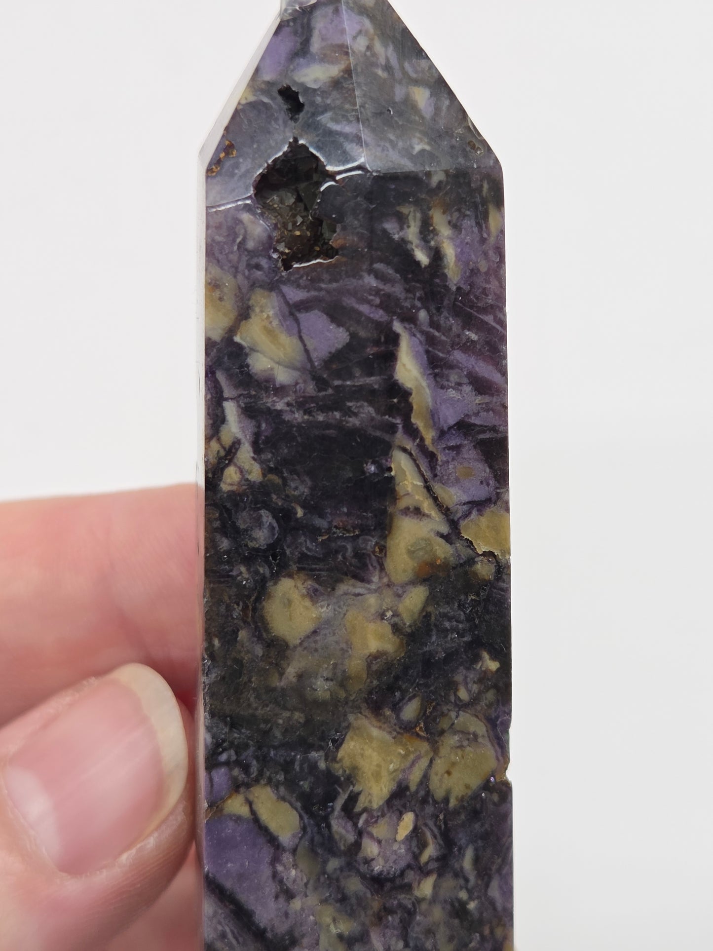 Close-up of a Brecciated Fluorite tower against a white background