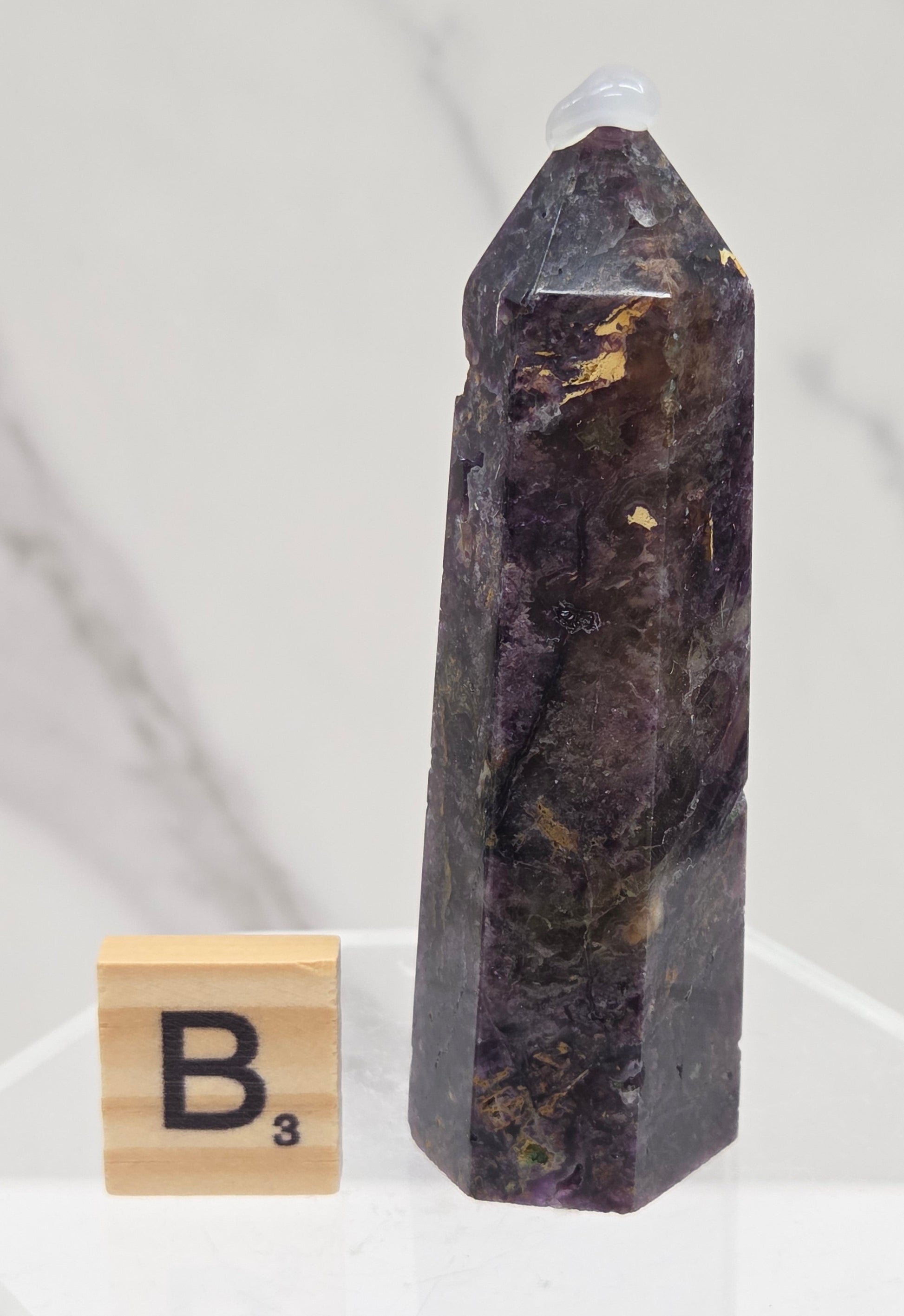 Brecciated Fluorite tower against a white background