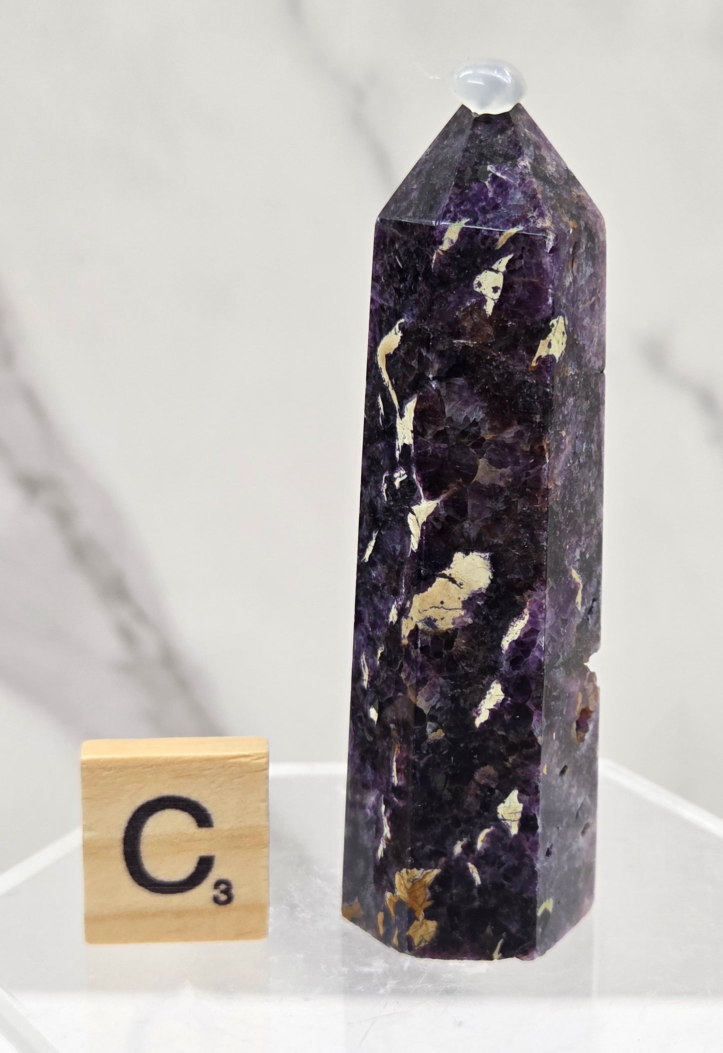 Brecciated Fluorite tower against a white background