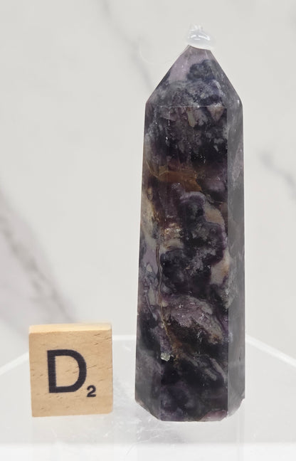 Brecciated Fluorite tower against a white background