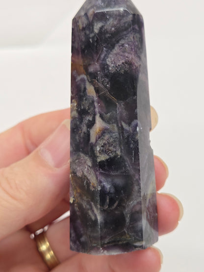 Brecciated Fluorite tower against a white background