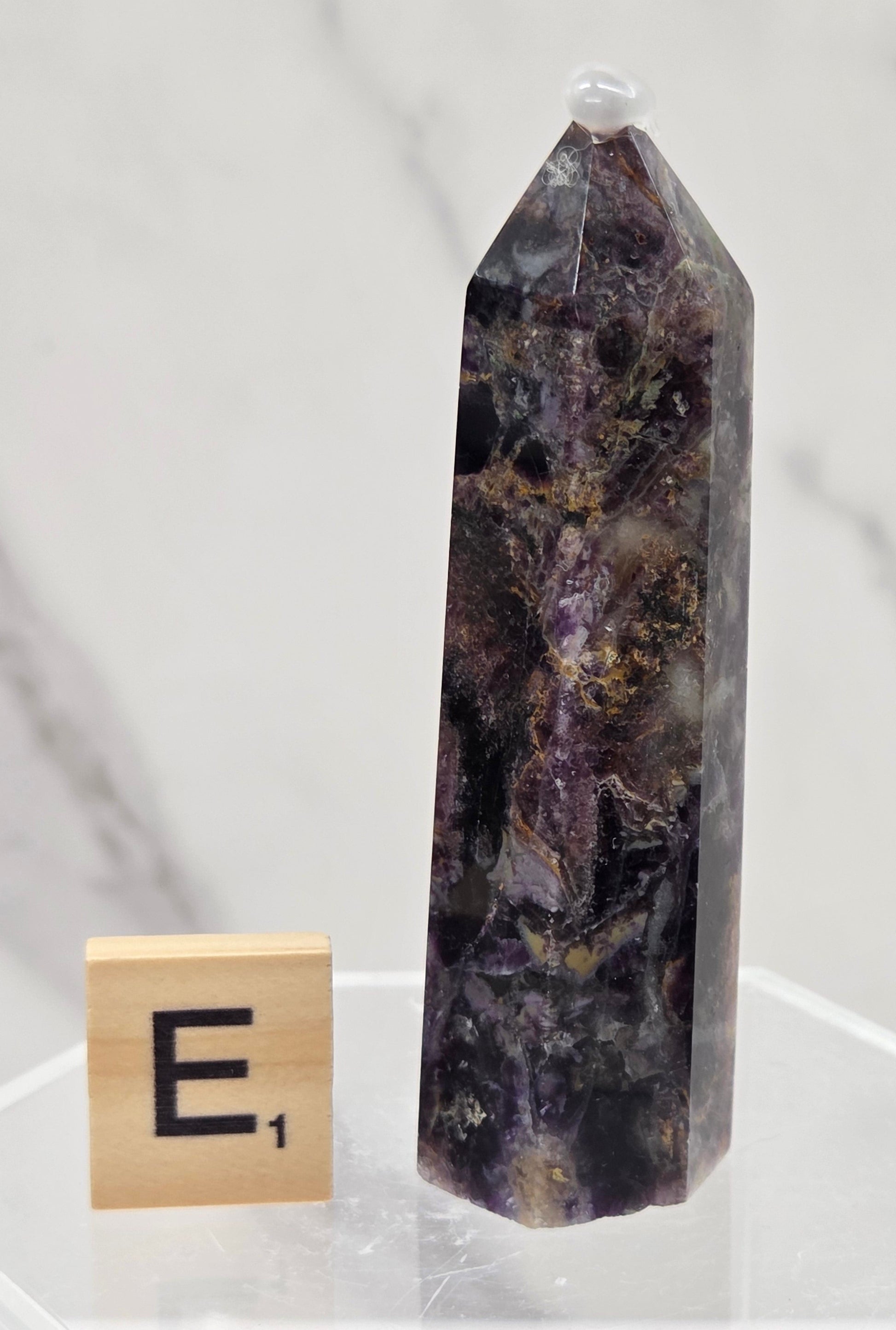 Brecciated Fluorite tower against a white background