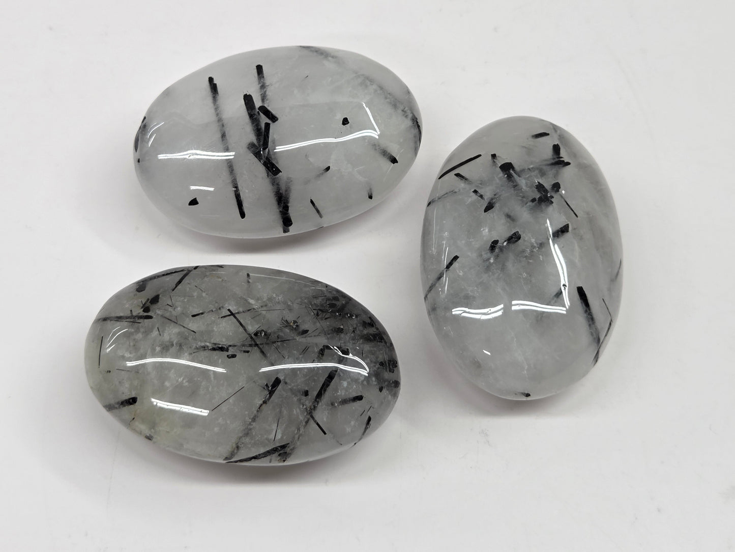 Palm shaped carvings made of Quartz with Tourmaline inclusions on a white background