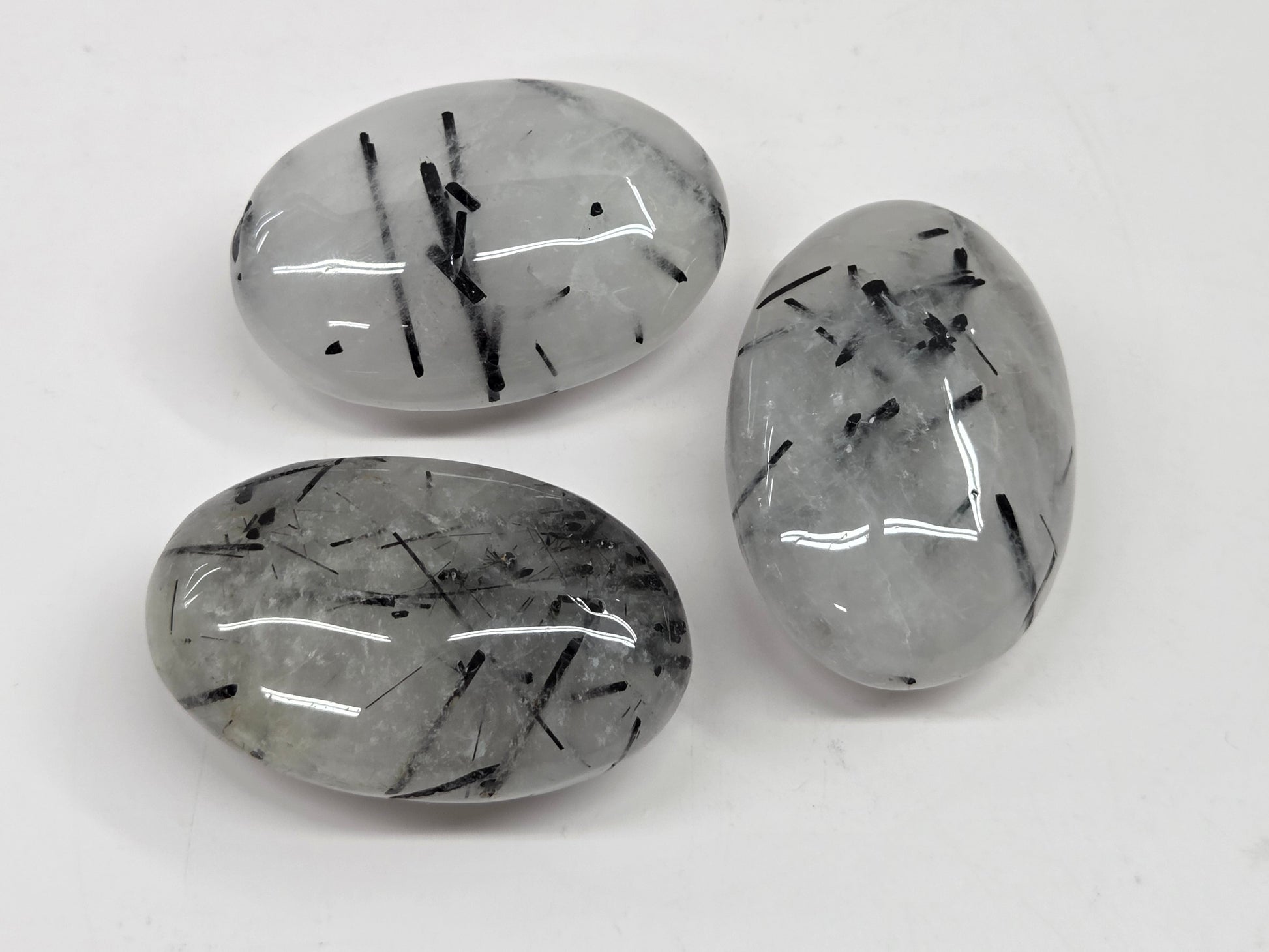 Palm shaped carvings made of Quartz with Tourmaline inclusions on a white background