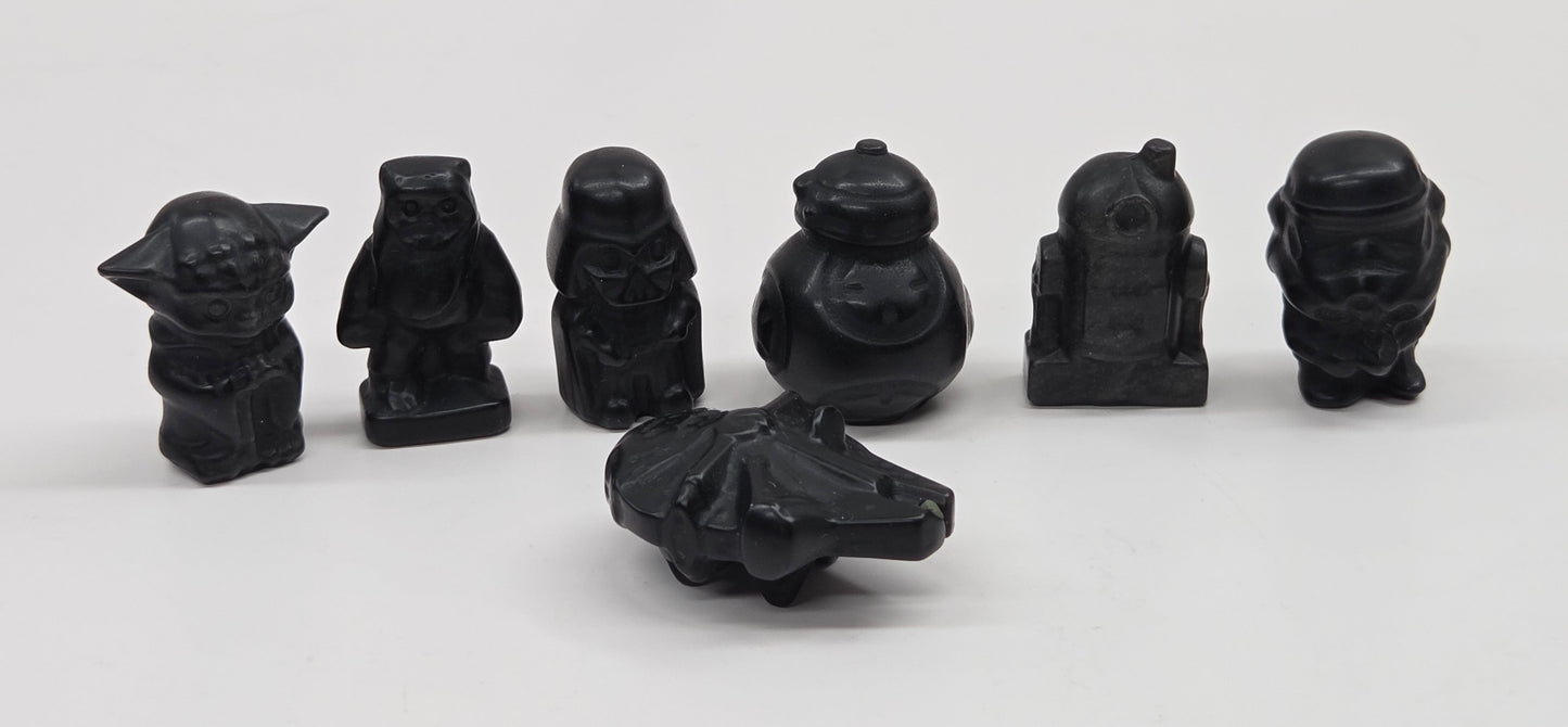 Set of 7 Star Wars character carvings made of Obsidian on a white background
