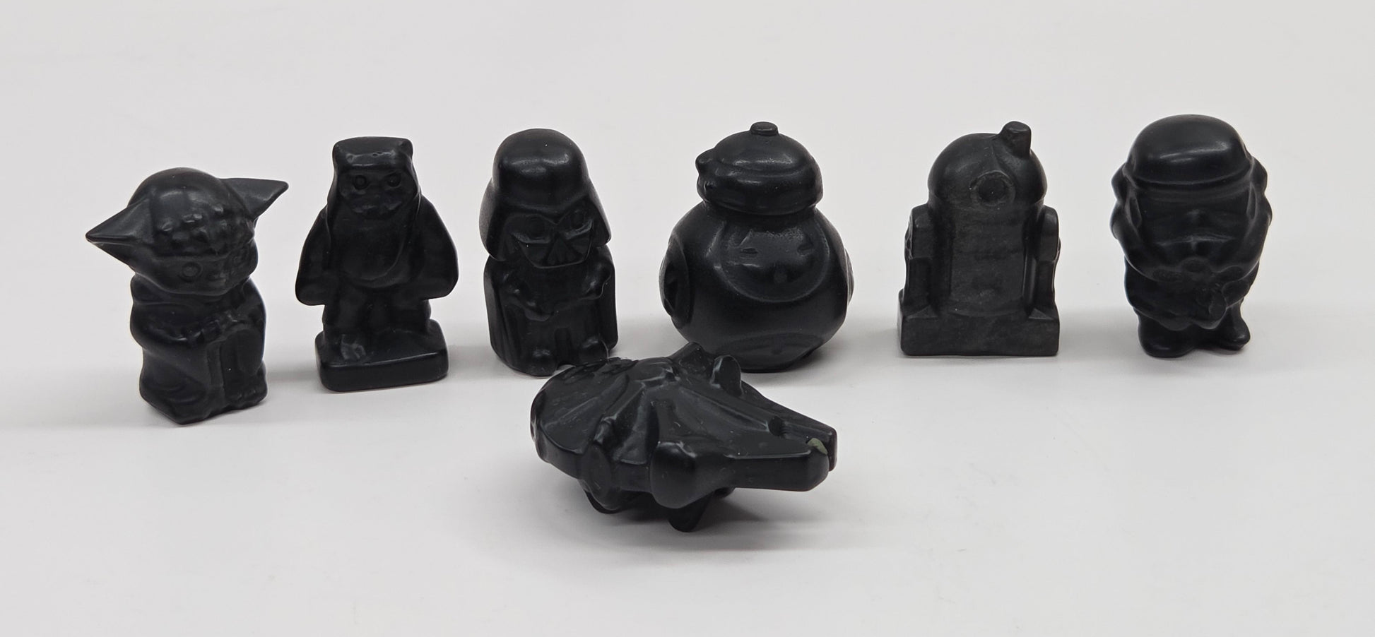 Set of 7 Star Wars character carvings made of Obsidian on a white background