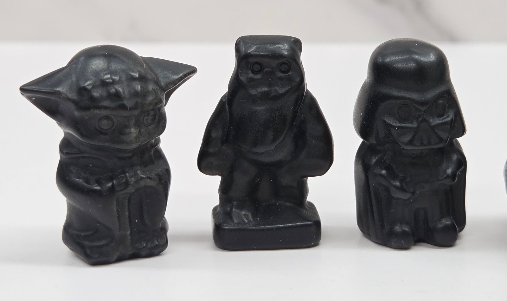 Set of Star Wars character carvings made of Obsidian on a white background