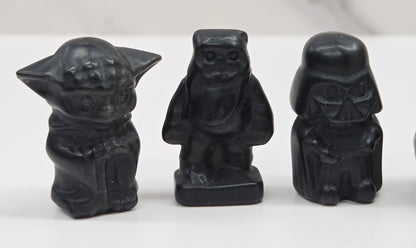 Set of Star Wars character carvings made of Obsidian on a white background