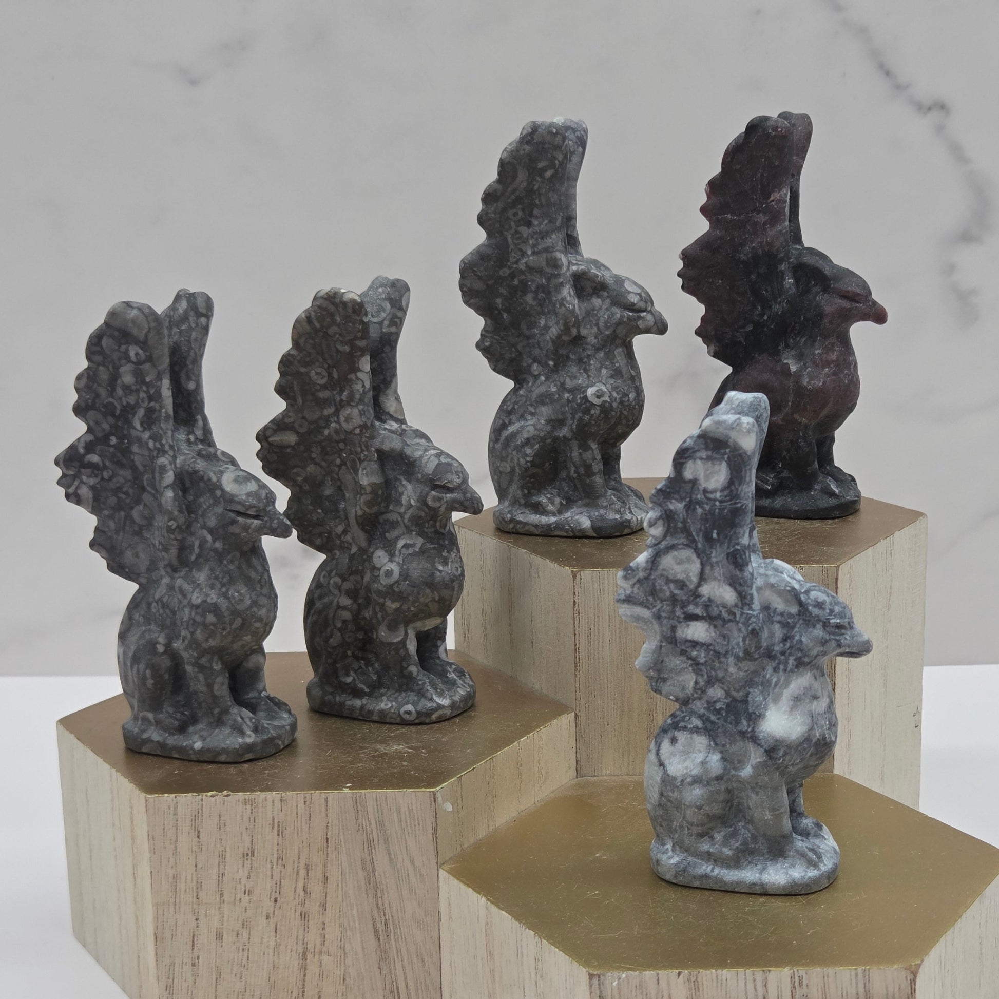 Set of stone sculptures on a wooden stand against a marble background