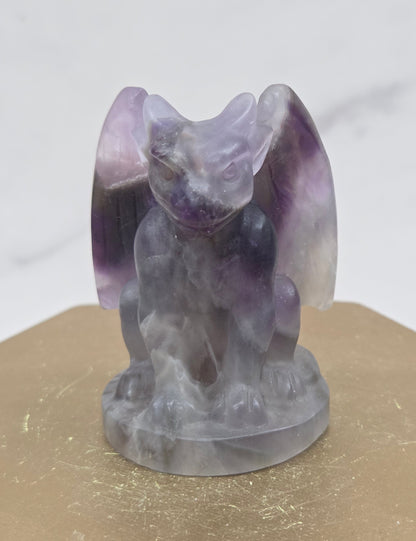 Decorative Amethyst gargoyle carving  on a wooden surface with a white background