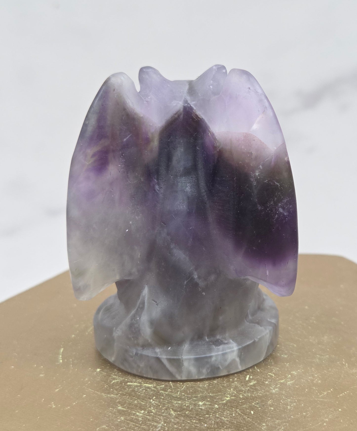 Decorative Amethyst gargoyle carving  on a wooden surface with a white background
