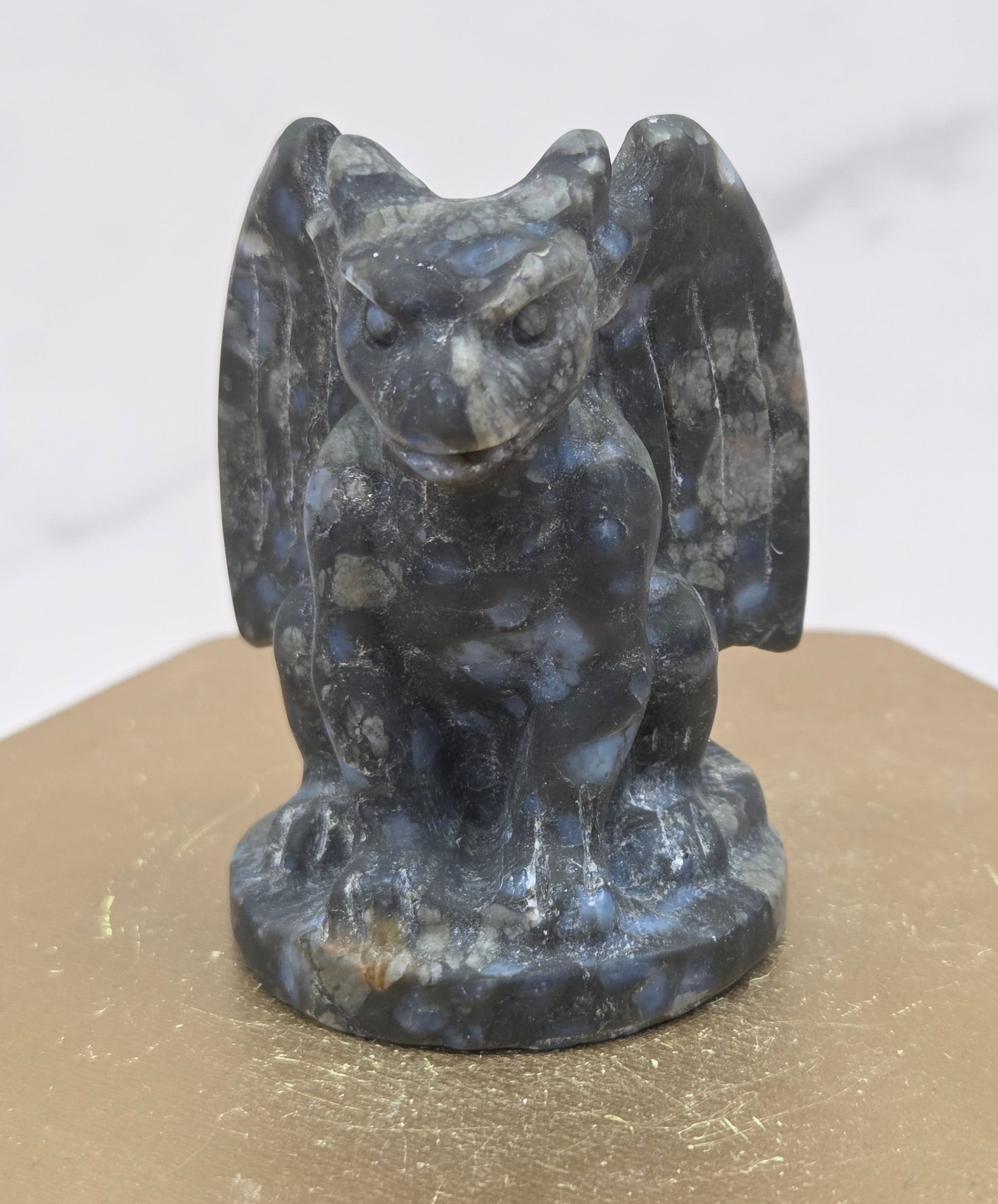 Decorative Que Sera gargoyle carving  on a wooden surface with a white background