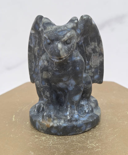 Decorative Que Sera gargoyle carving  on a wooden surface with a white background