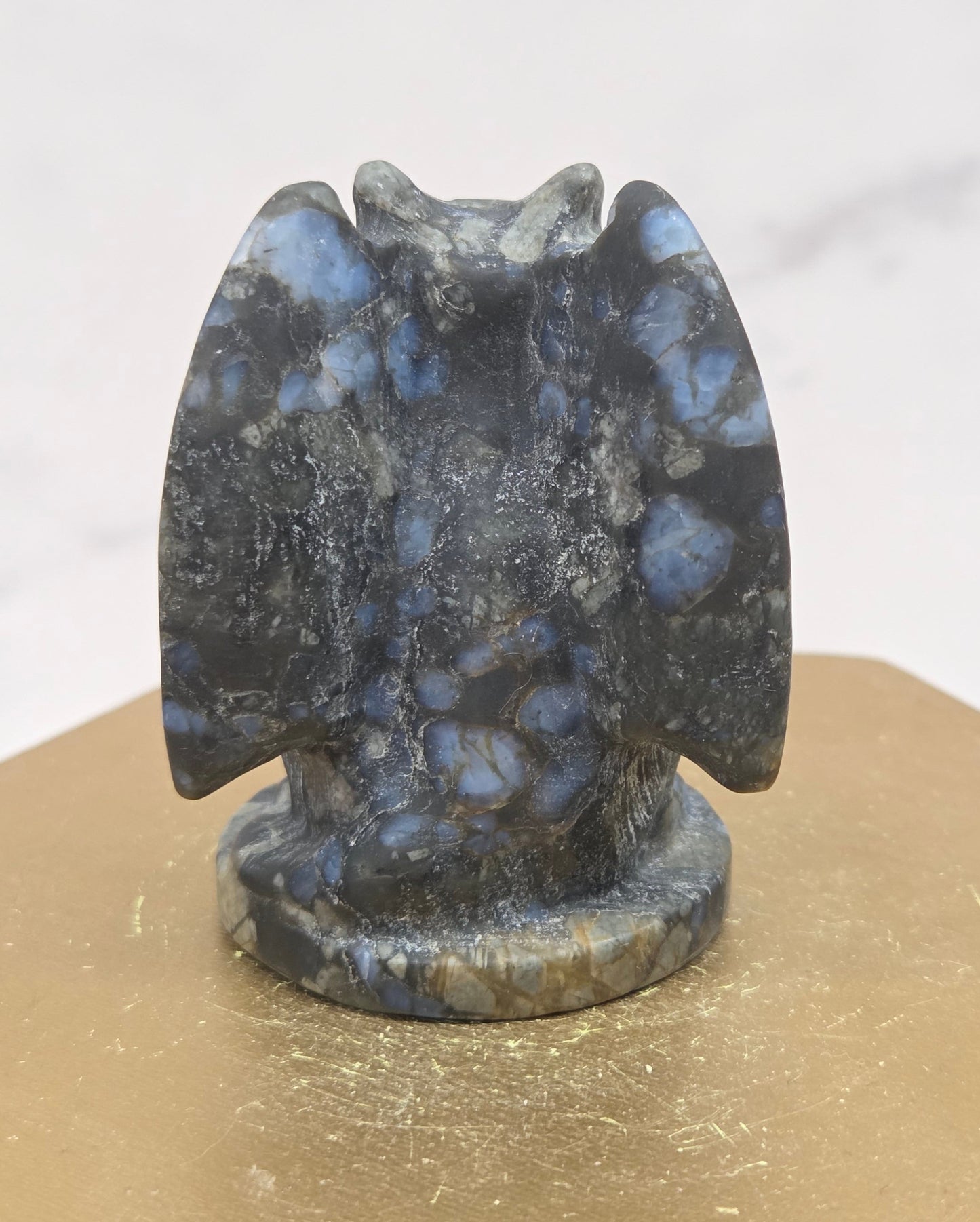 Decorative Que Sera gargoyle carving  on a wooden surface with a white background