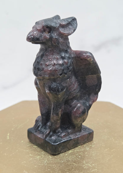 Decorative Garnet griffon carving on a wooden surface with a white background