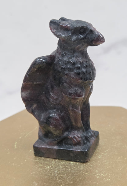 Decorative Garnet griffon carving on a wooden surface with a white background