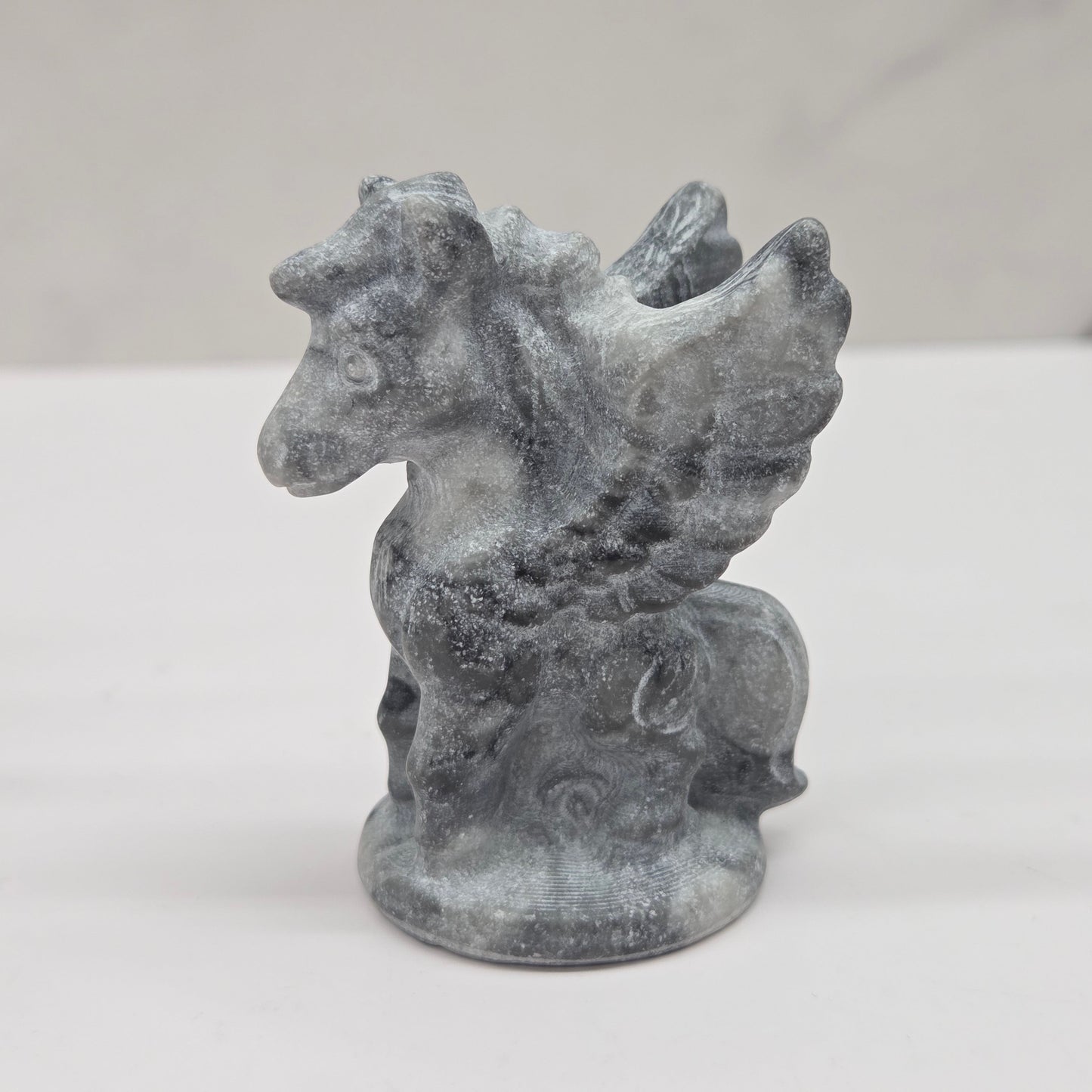 Stone sculpture of a winged creature on a white background